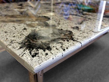 A tabletop covered with layers of resin through which paint was swirled