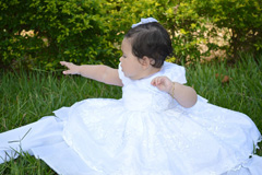 A baby girl in her baptism dress, formal attire