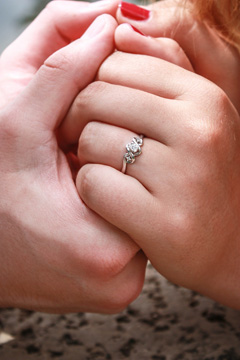 An image of devotion - the couple holding hands, her ring evident